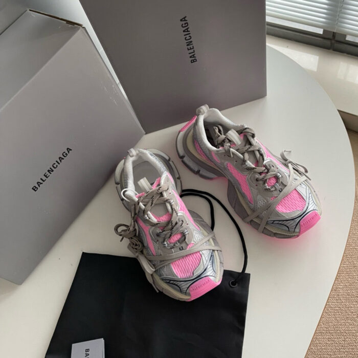 Sneakers Balenciaga grigie con dettagli rosa e packaging di lusso in stile minimalista.