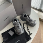 Sneakers Balenciaga grigie di lusso con scatole e dust bag, stile moderno e elegante.