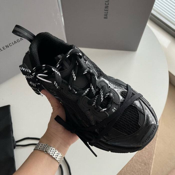 Sneaker nera di lusso con design moderno e dettaglio a zigzag, in ambientazione elegante.