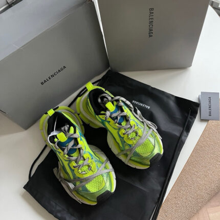 Sneakers neon Balenciaga, scatole di lusso e dust bag, stile moderno e alta moda.