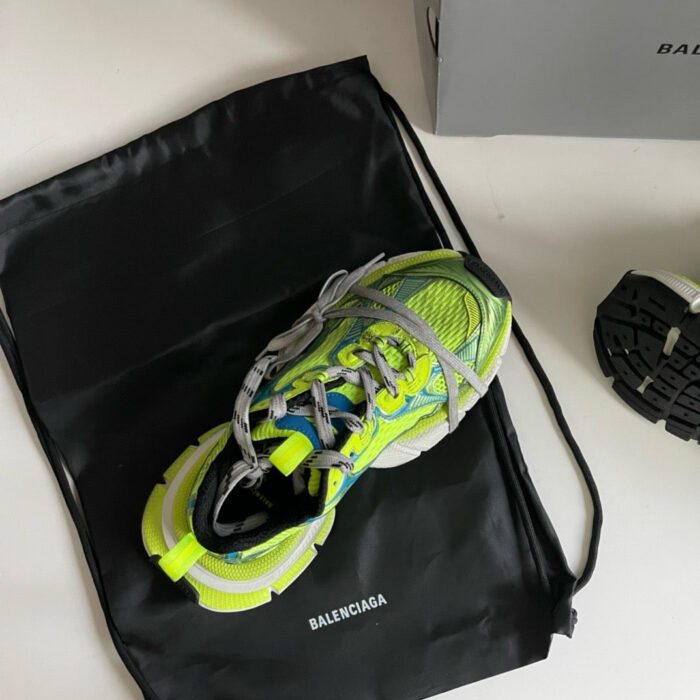 Sneaker Balenciaga neon con borsa nera, stile contemporaneo e design sportivo di lusso.
