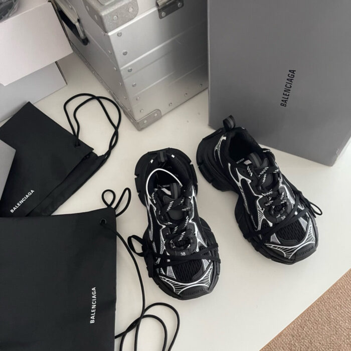 Sneakers di lusso nere con dettagli bianchi, accessori e confezioni eleganti in stile streetwear moderno.