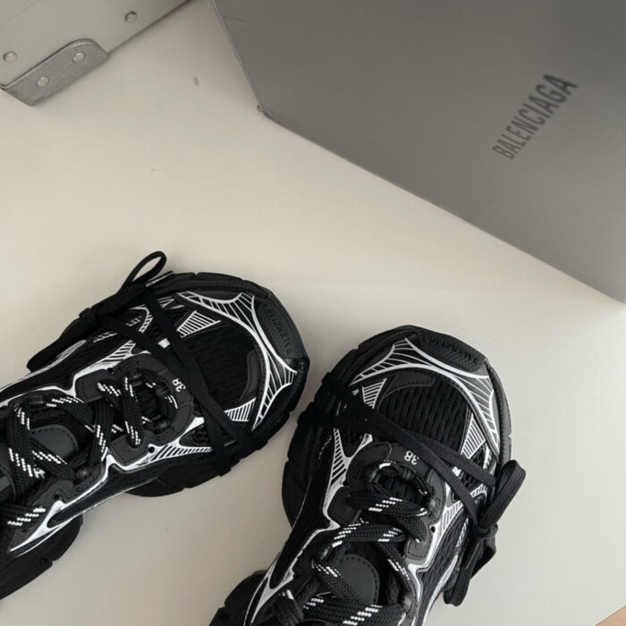 Sneakers Balenciaga nere e bianche dal design moderno e stile urbano.