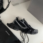 Sneaker nera con dettagli bianchi, stile moderno e casual, perfetta per look sportivi e di tendenza.