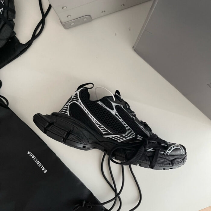 Sneaker nera con dettagli bianchi, stile moderno e casual, perfetta per look sportivi e di tendenza.