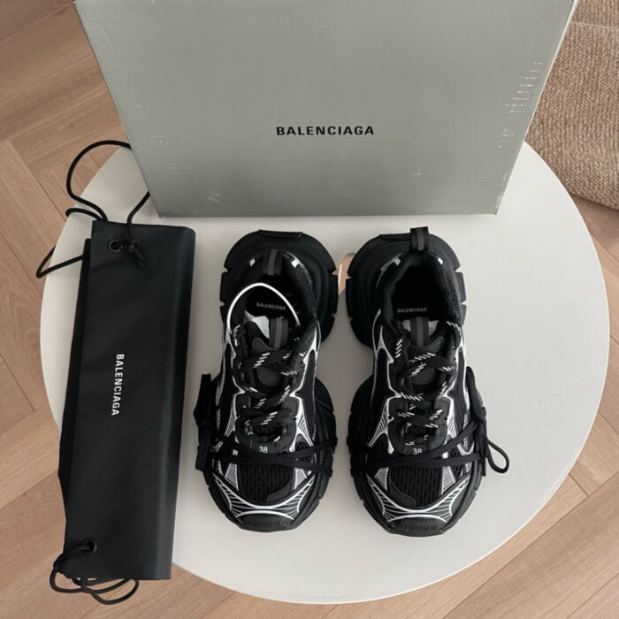 Sneakers Balenciaga moderne su tavolino bianco, design trendy e logo visibile.