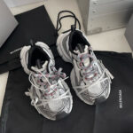 Scarpe Balenciaga sportive con dettagli rossi e suola antiscivolo dal design moderno e trendy.