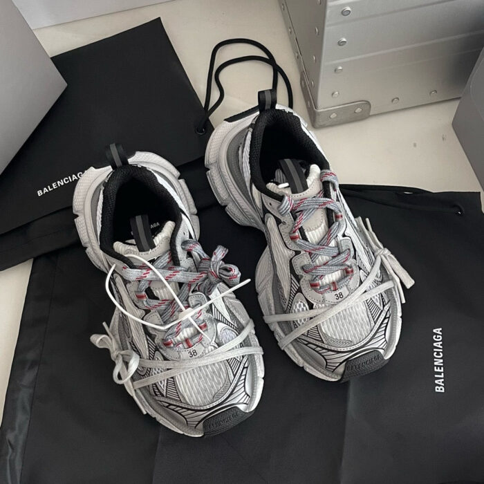 Scarpe Balenciaga sportive con dettagli rossi e suola antiscivolo dal design moderno e trendy.