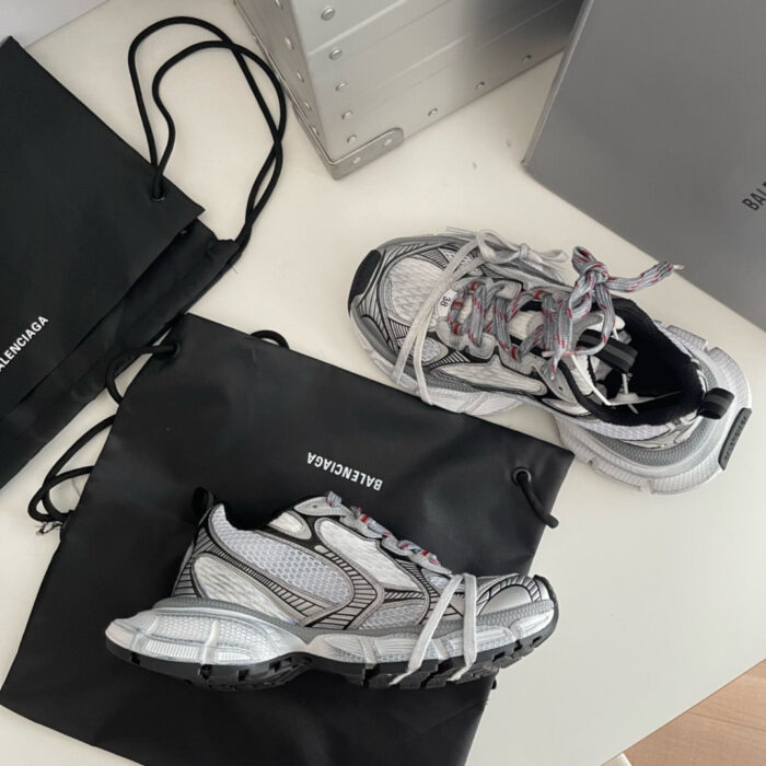 Sneakers Balenciaga con borse nere brandizzate, stile moderno e design elegante su superficie bianca.