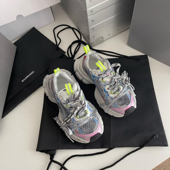 Scarpe sportive grigie con dettagli neon, accompagnate da eleganti borse di trasporto moderne.