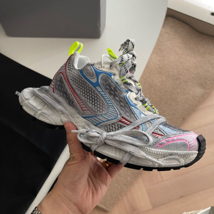 Sneaker moderna con dettagli riflettenti, colori vivaci e design innovativo per streetwear e comfort.