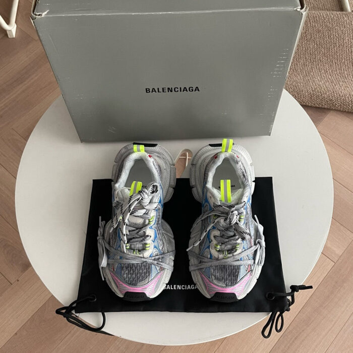 Sneakers Balenciaga colorate su tavolo di lusso, stile moderno e fashion.