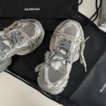 Sneakers Balenciaga di lusso posate su borsa elegante, stile moderno e high fashion.