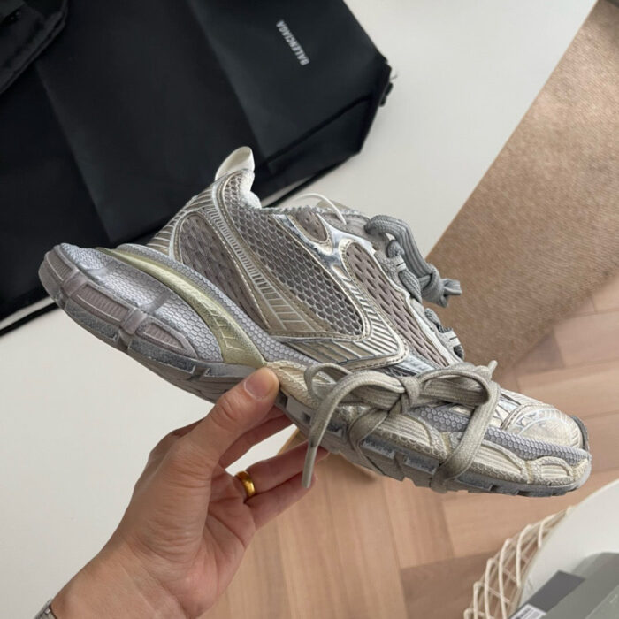 Scarpa da corsa moderna con dettagli riflettenti e design aerodinamico, ideale per attività sportive.