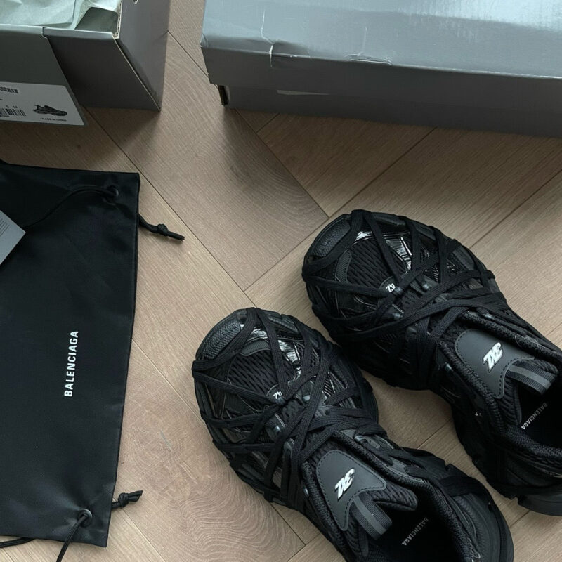 Sneakers di design con borsa di lusso su pavimento in legno, stile elegante e moderno.
