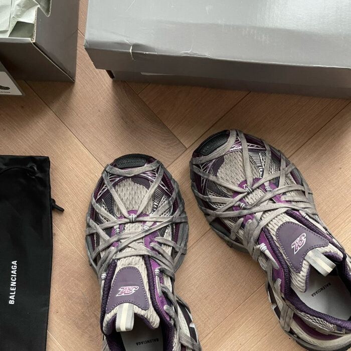 Sneaker di lusso Balenciaga su pavimento in legno, stile moderno e dettagli raffinati.