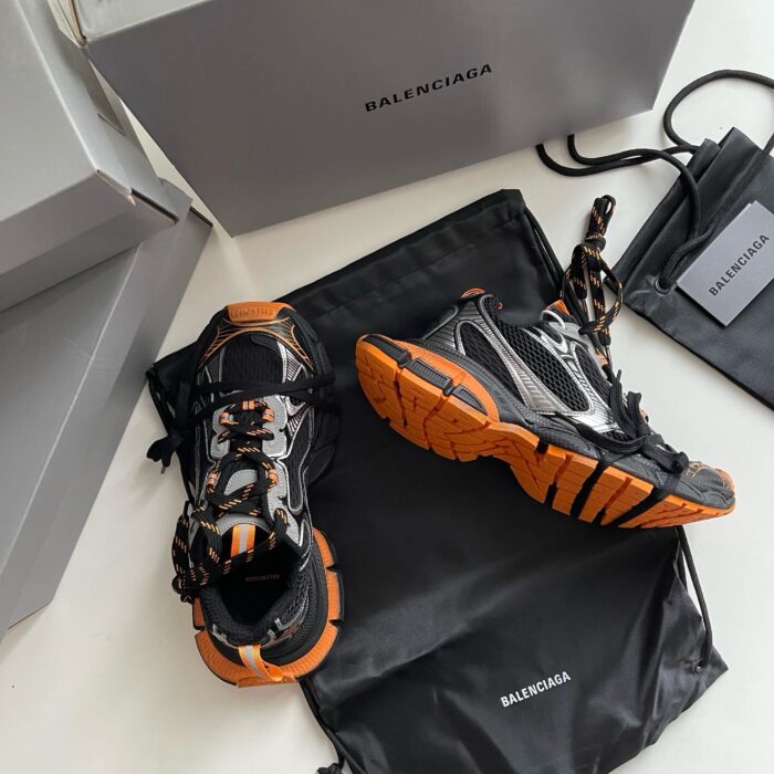 Sneaker Balenciaga high-end con scatole, borsa elegante e design innovativo, stile urbano di lusso.
