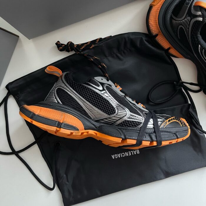 Scarpe sportive Balenciaga nere e arancioni con borsa di lusso, stile moderno e performance.