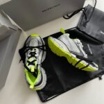 Sneakers Balenciaga neon green e grigie con logo di lusso e scatole eleganti.