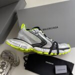 Scarpe Balenciaga sportive in argento con dettagli neon green, design moderno e stile urbano.