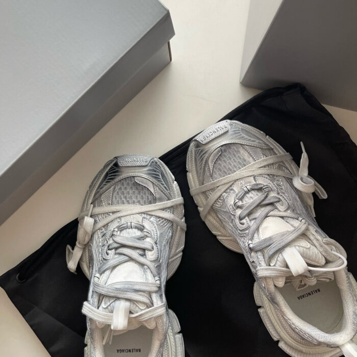 Sneaker moderne bianche con custodia nera e scatole eleganti, stile e funzionalità per appassionati di fashion.