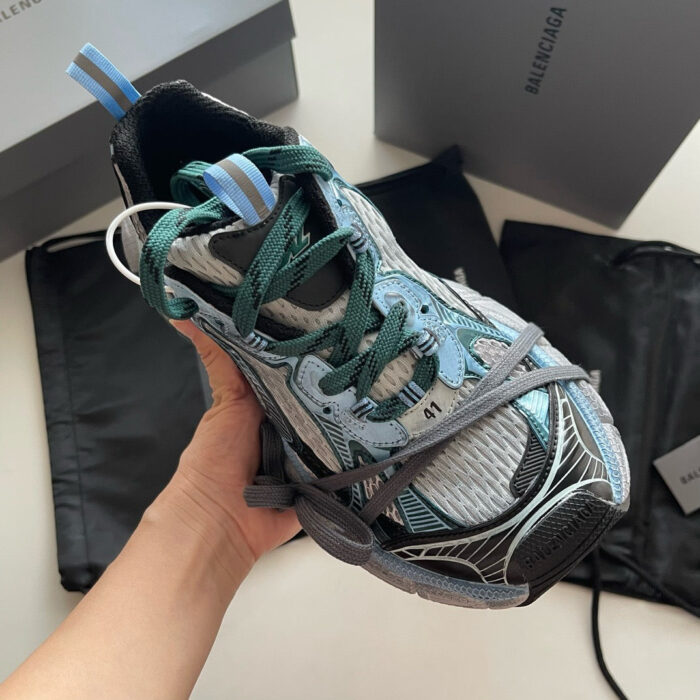 Sneaker di design moderno con dettagli teal, suola robusta e confezione di lusso.