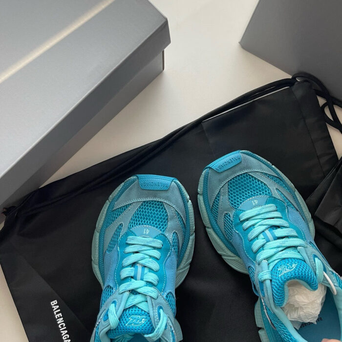Sneakers blu Balenciaga, scatole silver e custodia nera di alta moda.