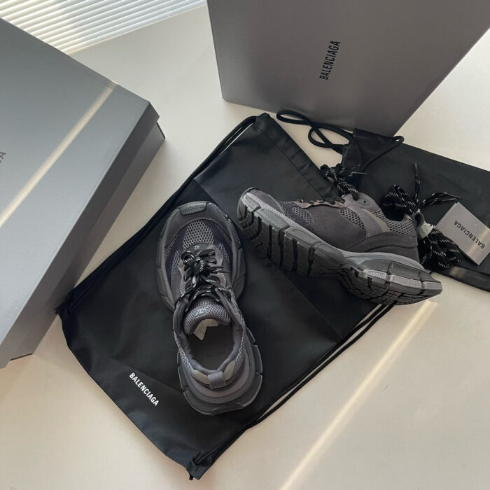 Scarpe sportive nere con borsa e scatole eleganti, stile moderno e di alta qualità.
