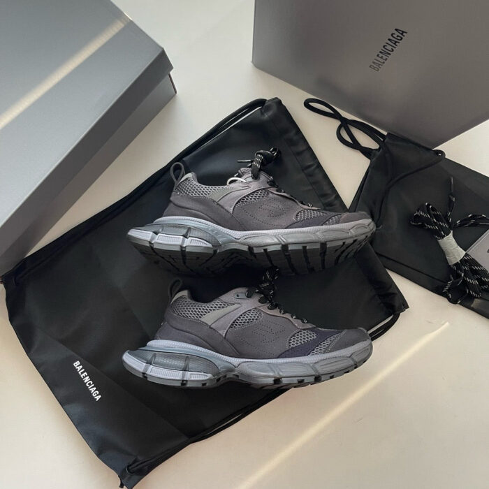 Sneakers di design con confezione di lusso, accessori eleganti e stile moderno raffinato.