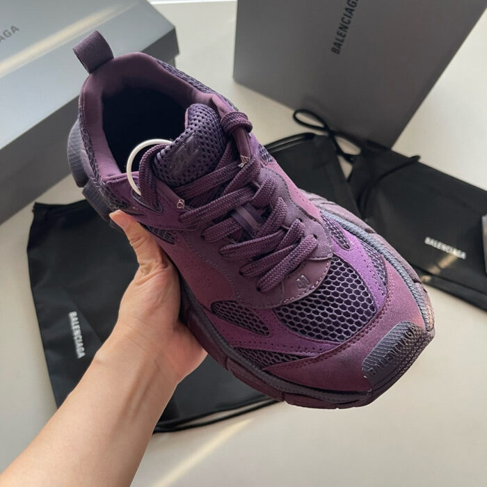 Sneaker viola di lusso con borse nere e packaging elegante, stilosa e moderna.