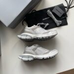 Scarpe da ginnastica di lusso con laccetti extra e packaging elegante, stile moderno e raffinato.