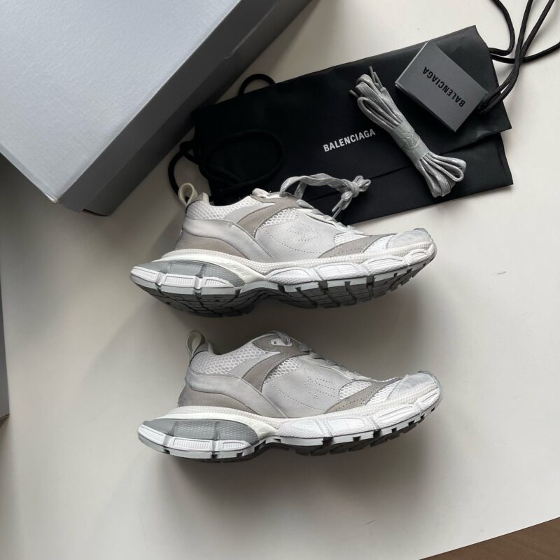 Scarpe da ginnastica di lusso con laccetti extra e packaging elegante, stile moderno e raffinato.