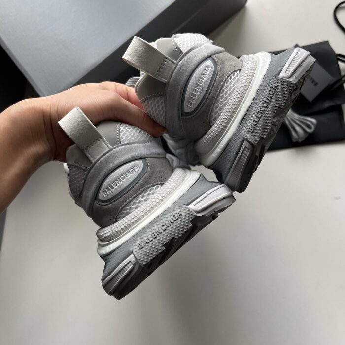 Sneakers moderne in grigio e bianco, comfort e stile, dettagli sportivi e suola antiscivolo.