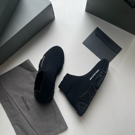 Scarpe nere di lusso in stile moderno, con packaging elegante e dettagli di alta moda.