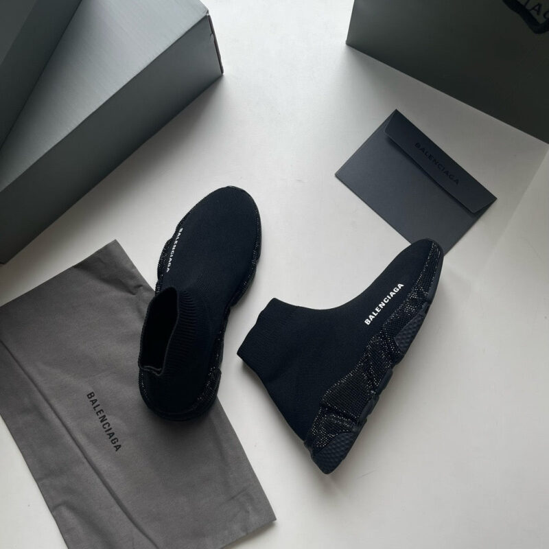 Scarpe nere di lusso in stile moderno, con packaging elegante e dettagli di alta moda.