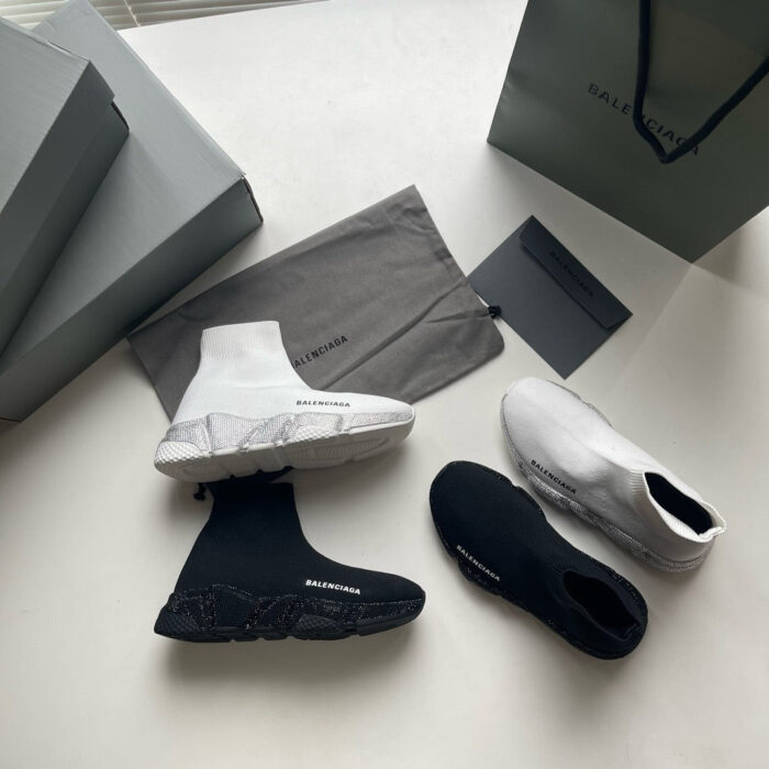 Sneaker high-top bianche e nere di lusso in stile minimalista con scatole e borsa brand.