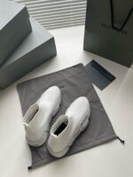 Sneaker all-white di lusso con packaging elegante e dettagli premium, stile moderno e sofisticato.