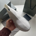 Sneaker bianca minimalista di lusso con design futuristico e dettagli eleganti.