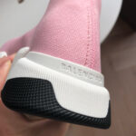Sneaker Balenciaga rosa, suola nera antiscivolo e logo raffinato, stile e comfort moderni.