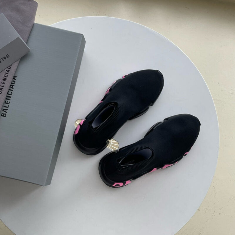 Scarpe Balenciaga nere con dettagli rosa, stile moderno, eleganza casual, mostrato su superficie bianca.