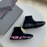 Sneakers nere di lusso con logo rosa, design moderno e elegante su packaging innovativo.