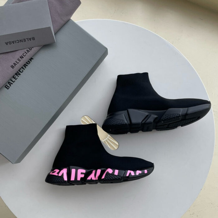 Sneakers nere di lusso con logo rosa, design moderno e elegante su packaging innovativo.