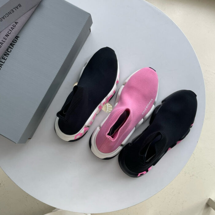 Sneakers moderne nero e rosa su tavolo rotondo, stile sportivo e trendy, nuove e eleganti.