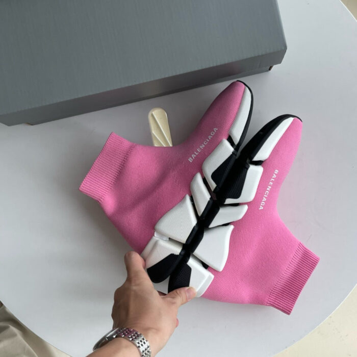 Sneakers rosa moderne con suola geometrica, comfort e stile, in primo piano su tavolo minimalista.