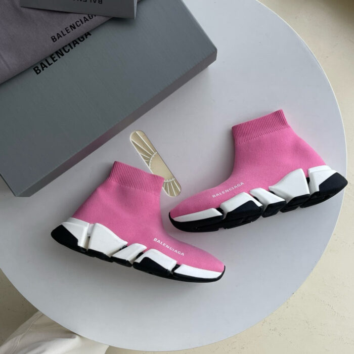 Scarpe Balenciaga rosa e nere con suola futuristica e branding elegante in stile streetwear.