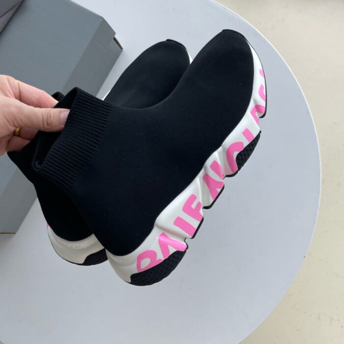 Sneaker nera moderna con suola bianca, dettagli rosa e design elegante e confortevole.