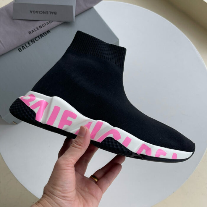 Sneaker nera moderna con dettaglio rosa e branding bianco, stile streetwear e comfort everyday.