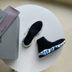 Scarpe Balenciaga moderne su tavolo minimalista, design elegante e logo distintivo.