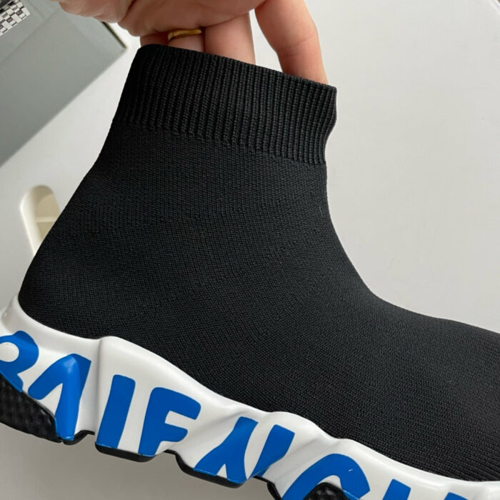 Sneaker minimalista in nero con suola bianca, dettagli blu e design moderno e confortevole.