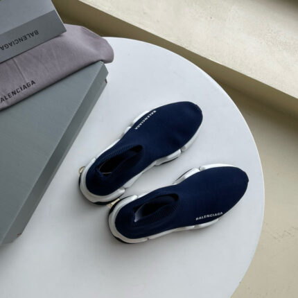 Scarpe Balenciaga navy moderne su tavolo elegante, con confezioni di lusso e stile minimalista.